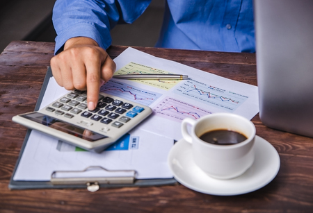 Close up man doing finance at home office with calculate expensesの写真素材
