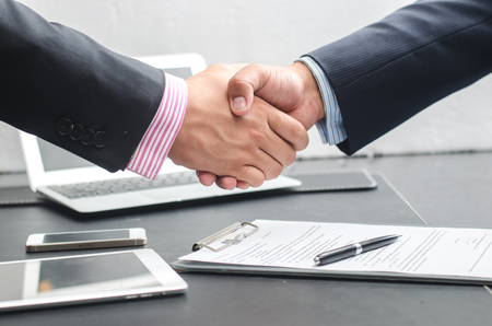 Close-up image of a firm handshake between two colleagues after signing a contractの写真素材