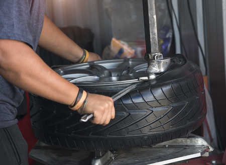 engineer balancing car wheel on balancer in workshopの写真素材