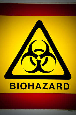 Biohazard symbol in black on a yellow warning triangle.の写真素材