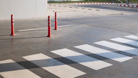 Road sign flexible plastic bollards with pedestrian white marking line and arrow sign on cement...