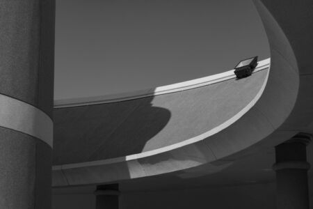 Low angle view of spotlight on top of modern roof in curve pattern against  clear sky background in black and white style, exterior architecture conceptの写真素材