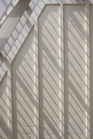 Sunlight and shadow on surface of white wooden roof truss structure under construction in vertical frameの写真素材