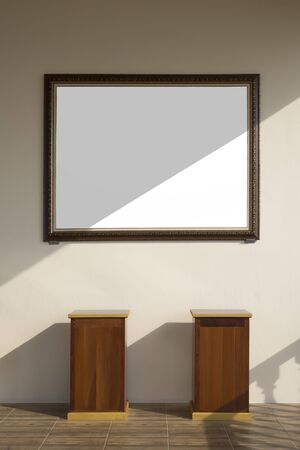 Sunlight and shadow on surface of vintage blank photo frame on mastic yellow cement wall with 2 wooden stands on wood tile floor in vertical frame, interior architecture conceptの写真素材