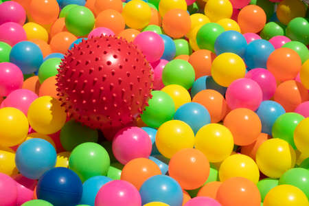 Cleaning of red rubber toy ball with spikes and multicolored plastic balls by washing the water and exposing to the sunの写真素材