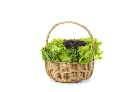 Various fresh salad vegetables in bamboo basket on isolated white background