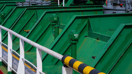 Side view of metal pipes of green oil tanks with white railing on crude oil tankerの写真素材