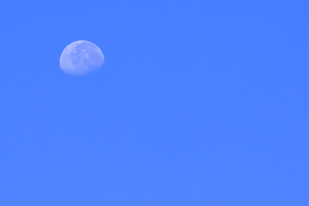 Waxing moon over blue sky at morning time in minimal styleの写真素材