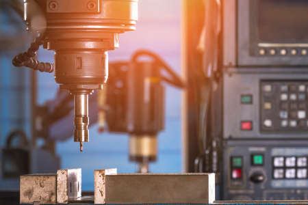 Close up of CNC milling machine tool with mill in chuck preparing to  process metal detail in...