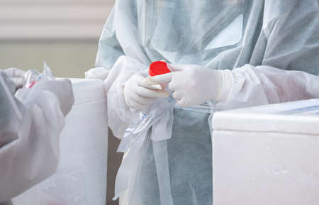 Focus at health worker's hand is collecting sputum and saliva samples to detect covid-19 infectious patients in public areaの写真素材