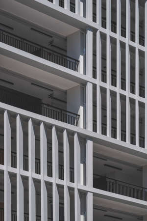 Low angle view of concrete sunshades wall with terrace of modern high residential building in vertical frameの写真素材