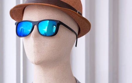 Close up of male mannequin wears sunglasses and fedora hat on white wooden wall backgroundの写真素材