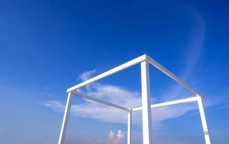 White steel structure of transparent cubic stand for travel photography against blue sky backgroundの写真素材