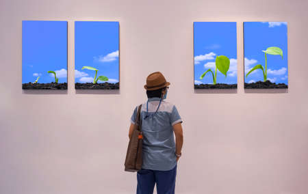 Rear view of Adult hipster woman in vintage clothing style looking at plant growing steps pictures...