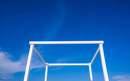 Simplicity summer background of white transparent cubic stand structure for travel photography against blue sky backgroundの写真素材