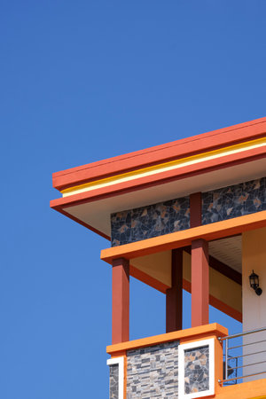 Low angle view of terrace of colorful vintage building against blue clear sky background in vertical...