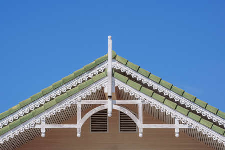 Front view of the old vintage gable roof against blue clear sky background