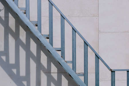 Outside steel baluster with staircase structure on gray smartboard wall background in house...