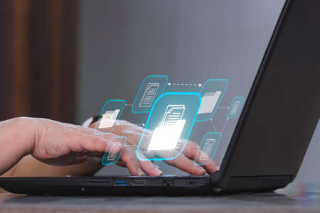 Woman hand using laptop with document management system (DMS) virtual screen, Concept of process automation to efficiently manage filesの写真素材