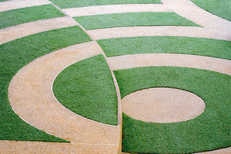 Abstract background of green artificial grass and gravel stone in circle pattern and different level...