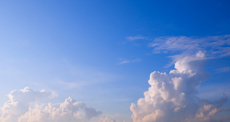 Morning sunlight with white cumulus clouds on blue sky background in wide screen view