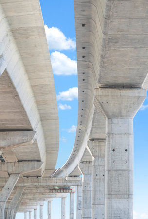 Flyover foundation posts structure under construction against blue sky in vertical frameの写真素材