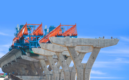 Launching gantry Structure for installing concrete Segment Joint on foundation of Flyover Expressway in road Construction site against blue sky backgroundの写真素材