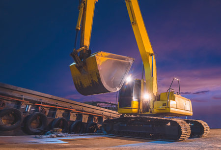 Yellow excavator is working to transfer paddy rice into the barge at port against night sky backgroundの写真素材