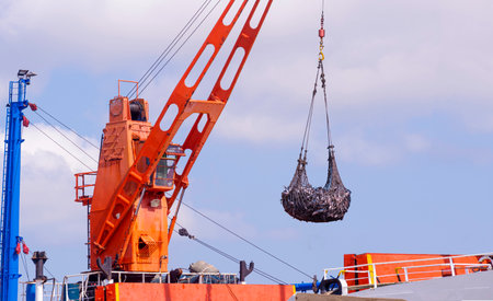 Crane on large fishing boat is lifting tuna fish to transferring into Refrigerated truck at harborの写真素材