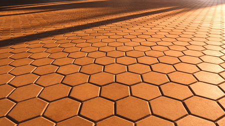 Background and Texture of Geometric Hexagon Brown Cobblestone Pavement in vintage style with Golden Sunlight Reflection and Shadow on Surfaceの写真素材