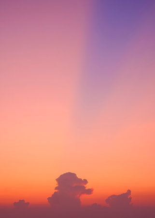 Beautiful Vertical Dramatic Dusk Sky background with cloud and majestic Orange sunlight on colorful Twilight sky after sundownの写真素材