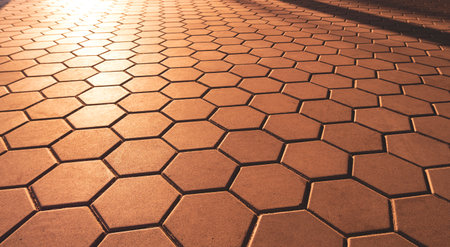 Geometric Pattern Background and Texture of Hexagon Brown Cobblestone Pavement in vintage style with Golden Sunlight and Shadow on Surfaceの写真素材