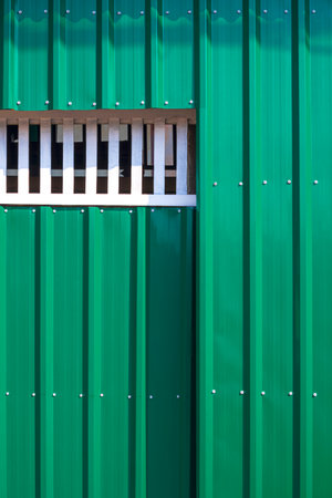 Green Sliding Entrance Door on Corrugated Steel Wall in Vertical frame, Street Minimal Exterior Architecture Backgroundの写真素材
