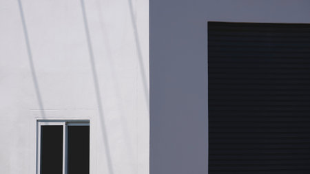 Sunlight and shadow on Glass sliding Window with roller shutter door of white warehouse building wall in perspective view, Minimal Exterior Architecture Backgroundの写真素材