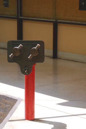 The old fire department connection on marble pavement floor outside of building in vertical frameの写真素材