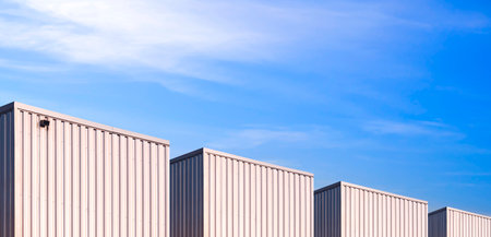 Panoramic view of industrial corrugated metal Warehouse Buildings group against blue Sky in perspective side viewの写真素材