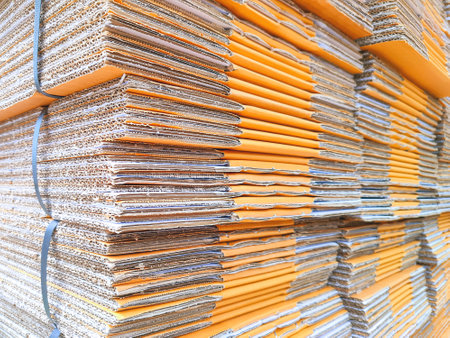 Group of many brown foldable cardboard boxes stacked for packaging in perspective side viewの写真素材