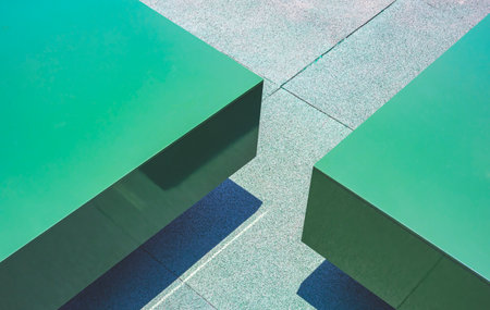 Part of 2 green rectangle benches made from aluminum composite tiles on artificial grass mat in public patio area, Geometric pattern backgroundの写真素材