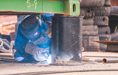 Welder is welding metal bollard to use for support foundation of the old container that have been...