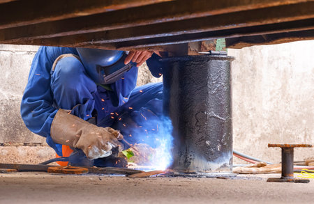 Welder is welding metal foundation to renovate and improvement outdoor office container
