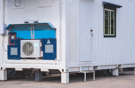 The old white office container with air conditioning and electrical system on courtyard floor in outdoor areaの写真素材