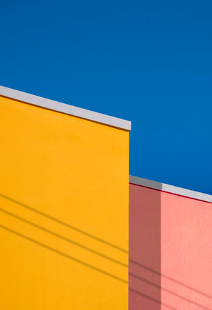 Minimal architecture background of colorful vintage building wall against blue clear sky in low angle view and vertical frameの写真素材
