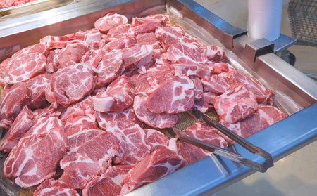 Many raw beef rib eye steaks for sale in frozen aluminum tray inside of supermarketの写真素材