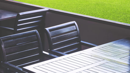 Row of black hardwood dining tables inside of vintage restaurant with light and shadow on surface, perspective side viewの写真素材