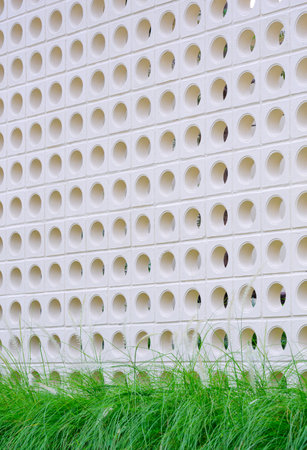 White circle ventilation block fence wall in modern loft style with fountain grass flowers outside of home, perspective side view and vertical frameの写真素材