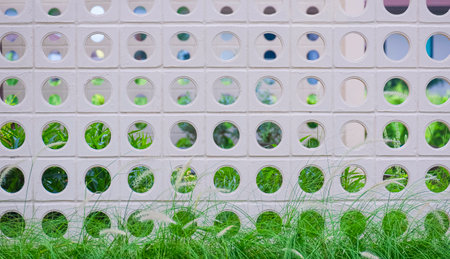 White circle ventilation block fence wall in modern loft style with fountain grass flowers outside...