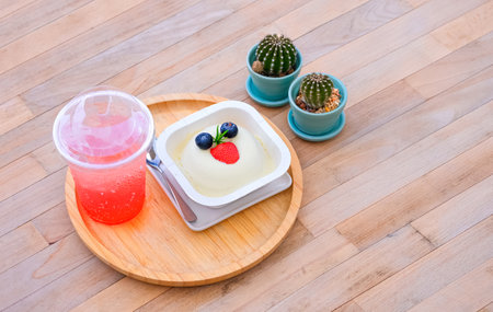 Strawberry soda juicy drink and blueberry cheesecake dessert with 2 little cactus on wooden tabletop in vintage style, high angle view with copy spaceの写真素材