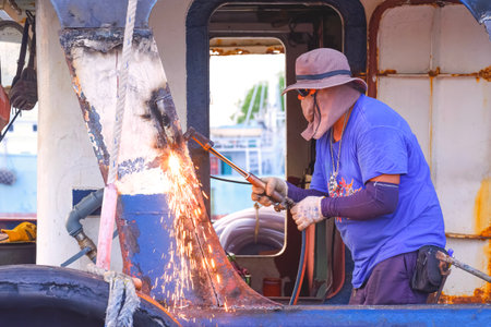 Welder is welding metal post surface of the old tanker ship during maintenance and improvement work...