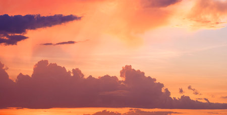 Silhouette dark clouds with orange sunlight on dramatic horizon sunset sky background in evening...