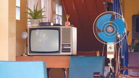 The old television and fan with household equipment in retro items inside of vintage house